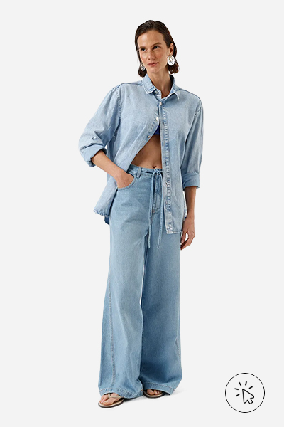 Modelo veste calça wide leg feminina jeans cintura média com cordão azul claro