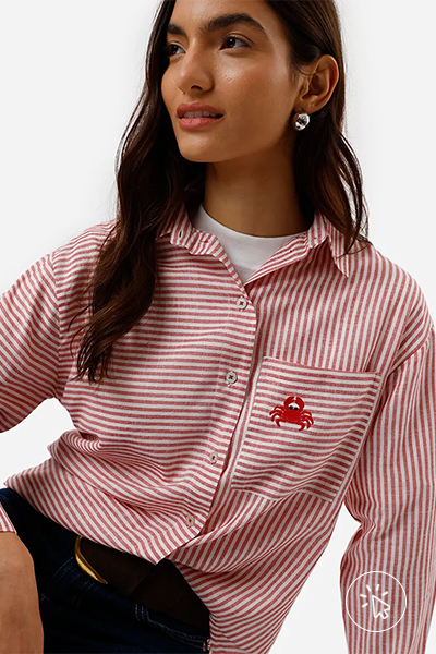 Modelo veste camisa oversized feminina com algodão bolso bordado listrada vermelha- que cores combinam com vermelho - cores de sapatos que combinam com vestido vermelho - cores que combinam com vermelho