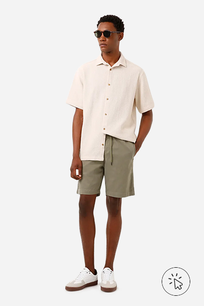 Modelo veste bermuda de sarja com cós de elástico verde militar