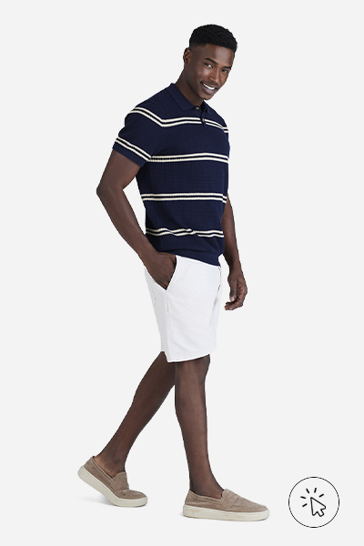 Modelo veste bermuda masculina branca e polo listrada azul marinho