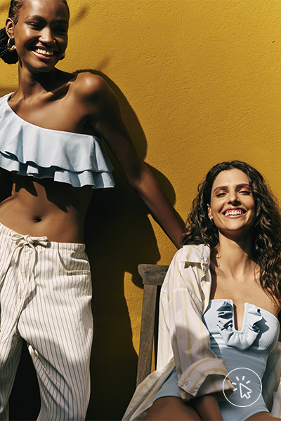 Modelos vestem top assimétrico com babados azul claro e calça off-white; e maiô com decote assimétrico azul claro e camisa feminina por cima