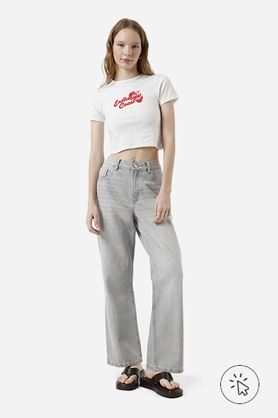 Modelo veste camiseta baby tee com frase "Endless Coast" e calça wide leg jeans cinza