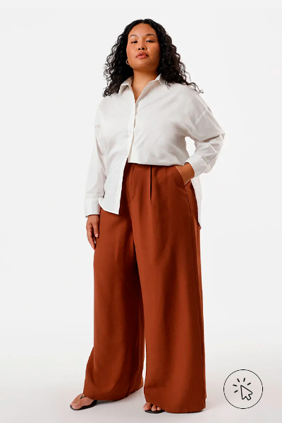Modelo veste calça alfaiataria com pregas e bolso plus size marrom