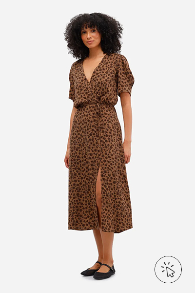 Modelo veste vestido mídi feminino de viscose floral com fenda marrom caramelo