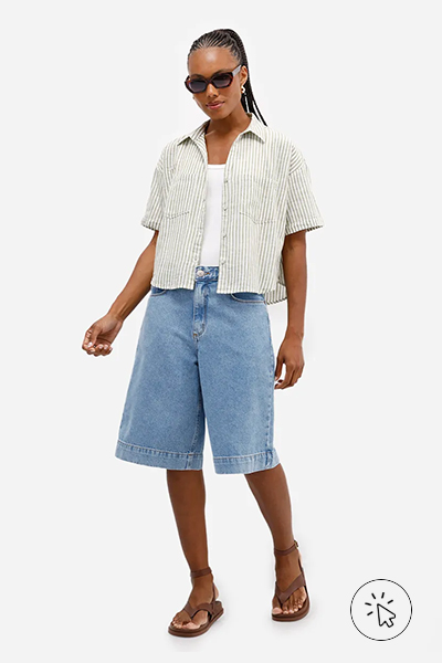 Modelo veste camisa de manga curta listrada verde, regata off-white, óculos escuros, jorts e rasteirinha marrom.- como usar camisa listrada