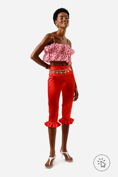 Modelo veste calça capri feminina com babados acetinada vermelha