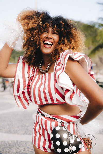 Duda Negrão veste top cropped mangas bufantes listrado vermelho e off-white no evento "Samba do bloco ao baile" Carnaval C&A