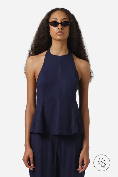 A modelo está usando uma blusa azul-marinho de peplum.