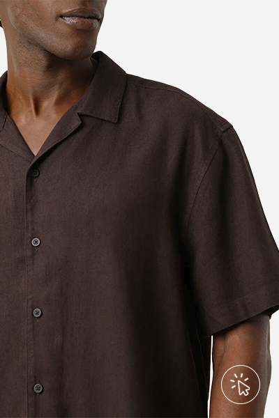 O modelo está usando uma camisa marrom e o crop está bem próximo da peça.