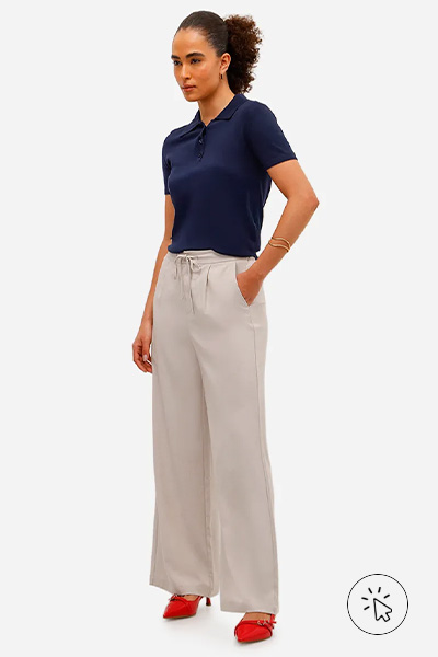 Modelo veste polo azul marinho, calça wide leg off-white e Scarpin salto baixa slingback vermelho