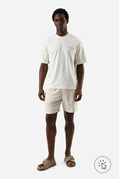 Modelo veste bermuda reta masculina de algodão texturizada off-white - tons neutros - tons neutros roupas - o que são tons neutros - como combinar tons neutros