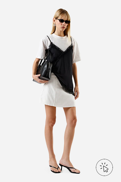 Modelo veste blusa assimétrica feminina com renda preta