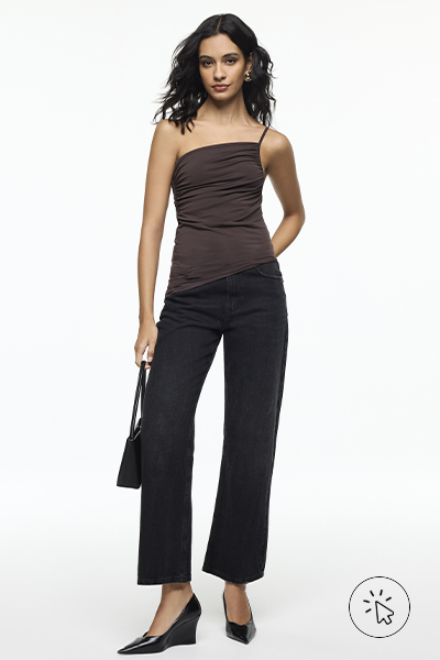 Modelo veste top assimétrico marrom e calça preta