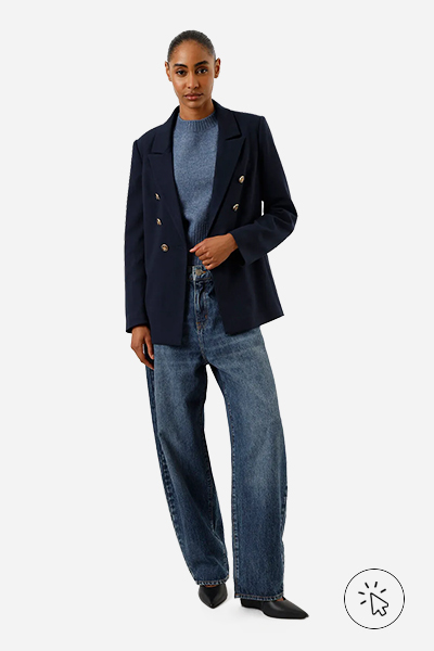 Modelo veste blazer em piquet com ombreiras azul marinho
