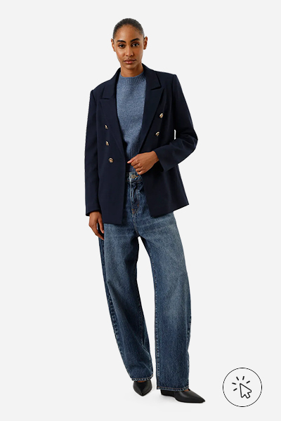 Modelo veste blazer em piquet com ombreiras azul marinho