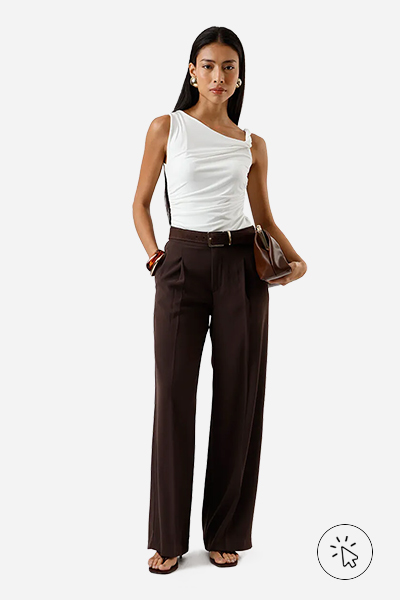 Modelo veste blusa franzida assimétrica off-white, wide leg de alfaiataria marrom, cinto, tamanco de salto fino preto, bolsa marrom e braceletes dourados - estilo minimalista - estilo minimalista feminino - o que é estilo minimalista