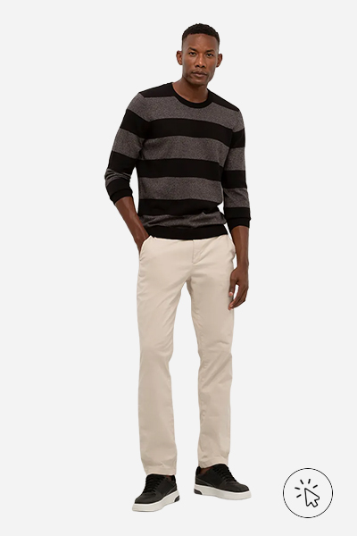 Modelo veste suéter listrado preto, calça de sarja bege e tênis preto - estilo minimalista - estilo minimalista masculino - o que é estilo minimalista