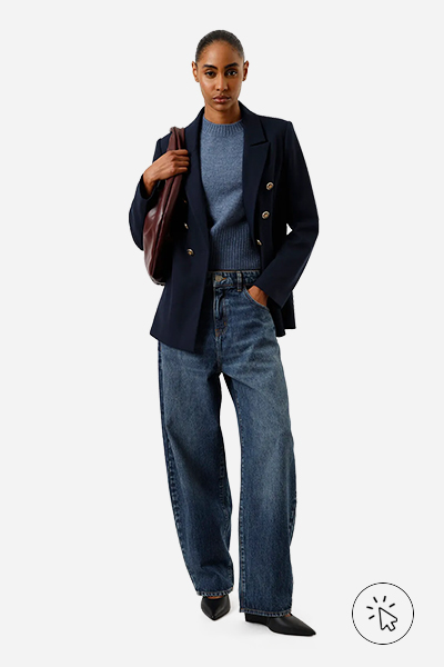 A modelo está usando calça jeans, tricô azul claro e blazer azul escuro - look monocromático - o que é monocromático - o que é look monocromático