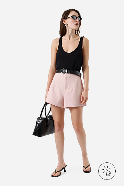 Modelo veste short de alfaiataria feminino com pences rosa claro - look para show à noite