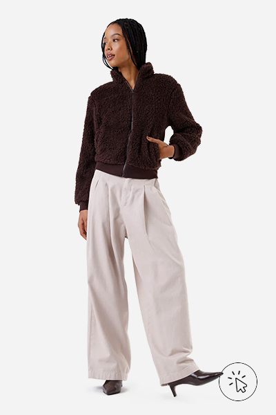 Modelo veste jaqueta de pelo com bolsos gola alta marrom