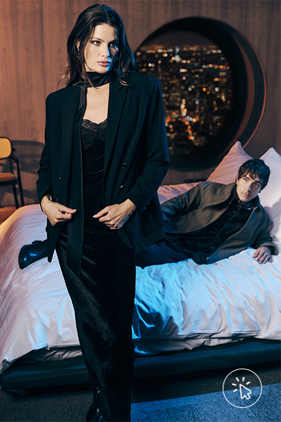 Isabeli Fontana veste vestido longo acetinado com renda preto e blazer de alfaiataria preto. Di Ferrero veste jaqueta de PU preta e camisa preta.
