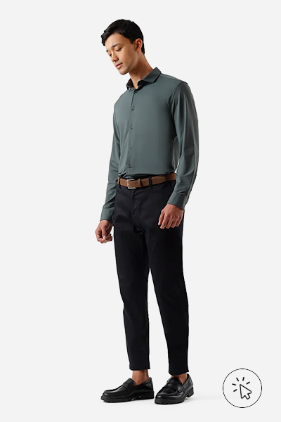 Modelo veste camisa slim fit verde, calça slim de alfaiataria preta, cinto marrom e sapato oxford preto - look masculino para casamento