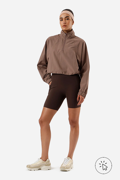 Modelo veste jaqueta feminina de poliamida esportiva gola alta com zíper marrom