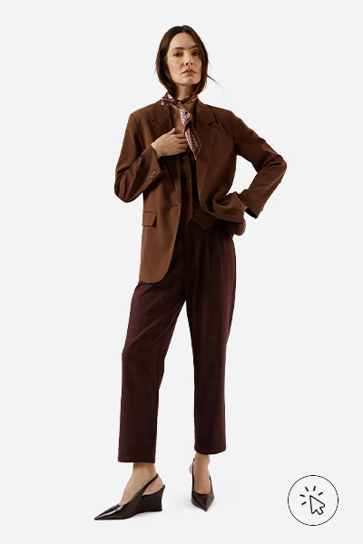 Modelo veste blazer marrom, colete, calça xadrez com pregas vinho, sapato de bico fino com plataforma anabela e lenço estampado no pescoço - tal mãe tal filha - o que significa tal mãe tal filha - roupa combinando mãe e filha