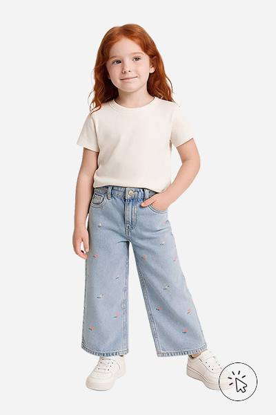 Modelo infantil veste wide leg jeans com bordado floral, camiseta branca e tênis branco - tal mãe tal filha - o que significa tal mãe tal filha - roupa combinando mãe e filha