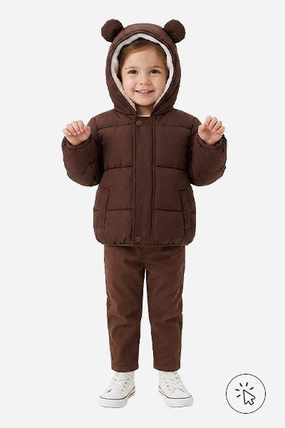 Modelo infantil veste jaqueta puffer marrom com capuz e orelhas 3D de urso, calça de moletom marrom e tênis branco - tal mãe tal filha - o que significa tal mãe tal filha - roupa combinando mãe e filha