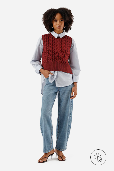 modelo veste colete de tricô terracota sobrepondo uma camisa de maga comprida, calça jeans e sandália de dedo - look com colete de tricô