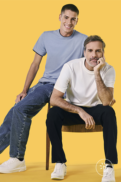 São dois modelos, o da esquerda está com calça jeans e camiseta azul e o da direita com calça preta e camiseta off-white